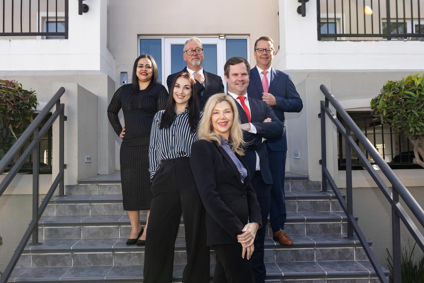 The six attorneys of Leon Frank & Partners on the steps of Cedar House, Somerset West