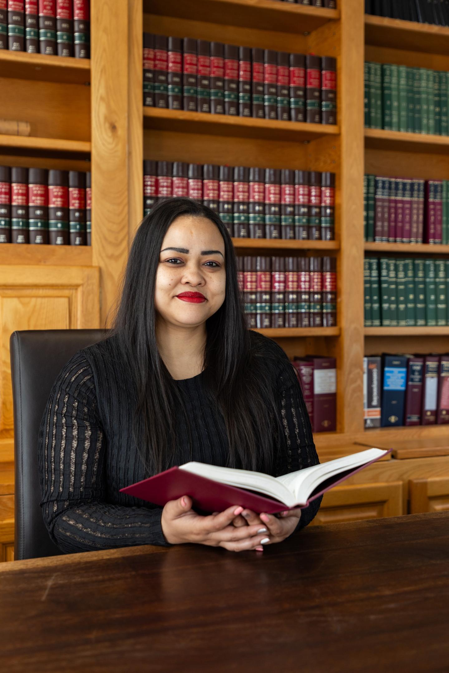 Marianne Blankenberg reading at a desk in the firm's law library