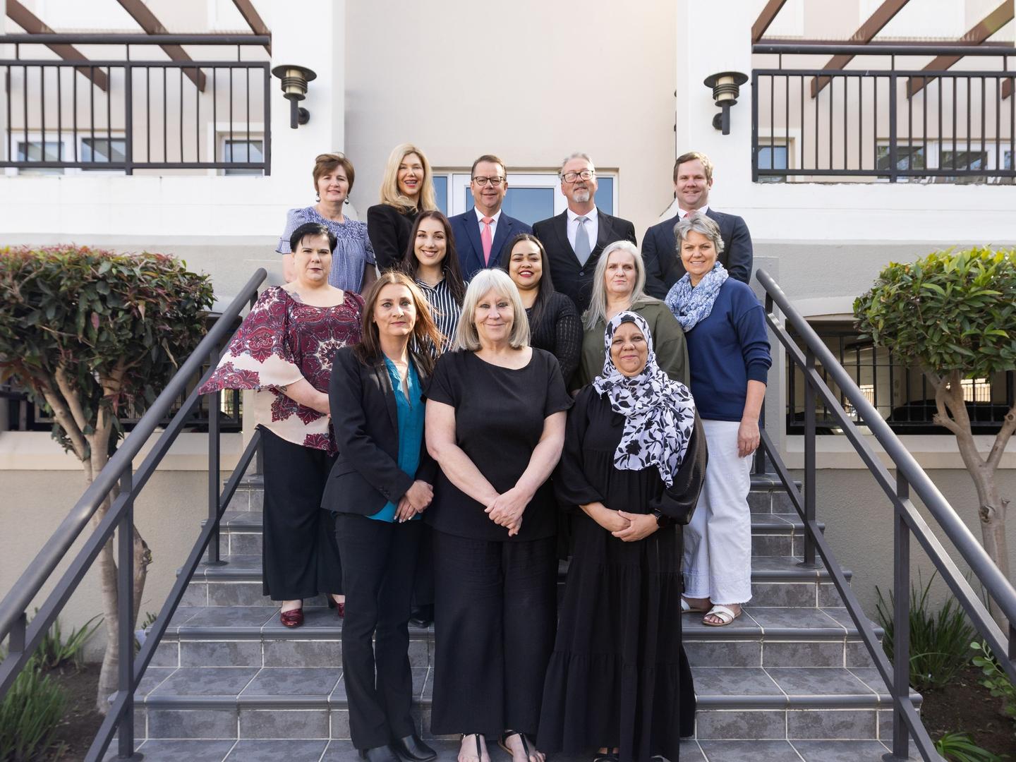 The attorneys and staff of Leon Frank & Partners in front of Cedar House